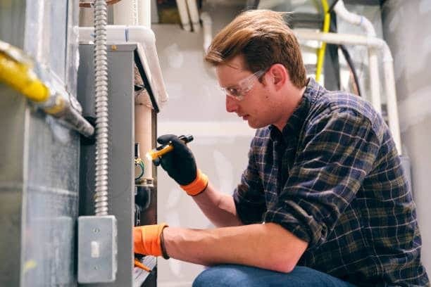 Technician performing industrial equipment maintenance with portable power support