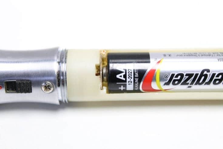 Battery corrosion inside flashlight indicating acid leak and smell