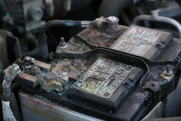 Heavy corrosion on the top of a leaking car battery under the hood