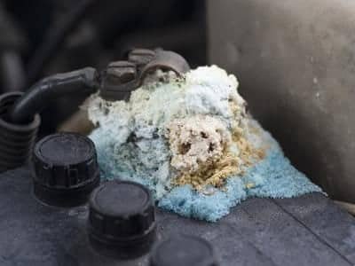 Severe corrosion at battery terminal caused by acid leak emitting smell
