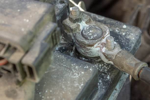 Close-up of a battery terminal with acid corrosion and white powder