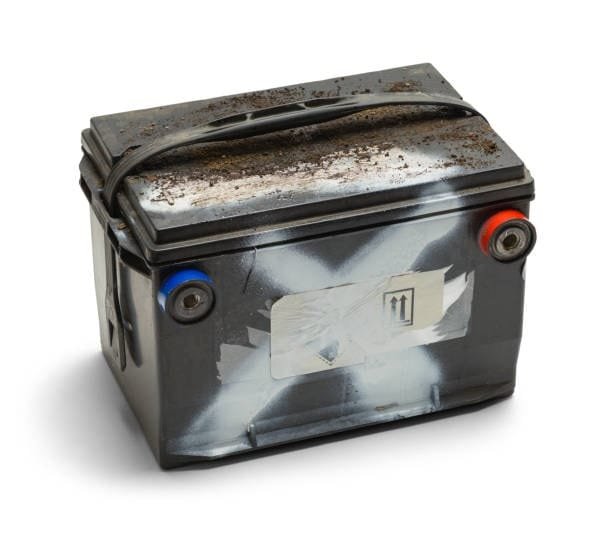Worn-out car battery with dirt buildup and acid leak signs