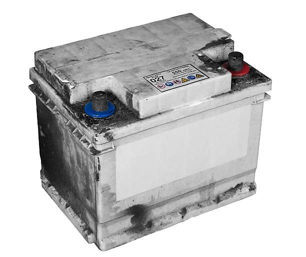 Old car battery showing signs of leakage, dirt, and acid residue