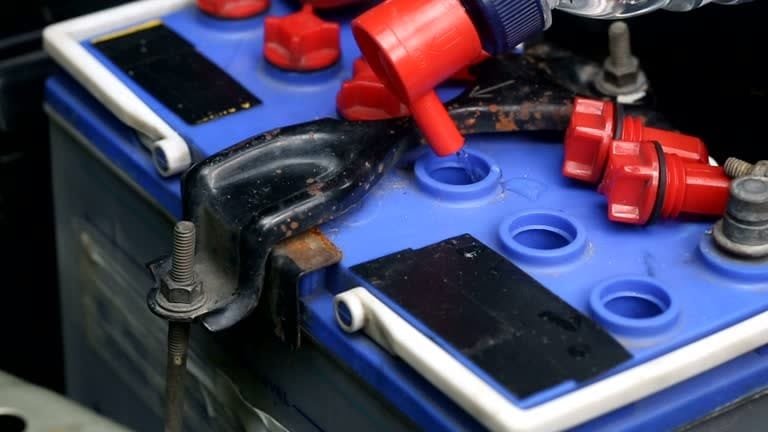 Refilling car battery cells with water to maintain electrolyte levels
