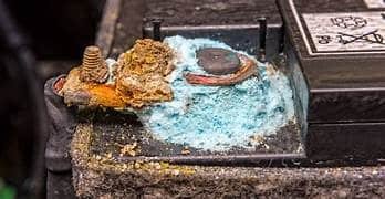 Heavy blue corrosion covering the car battery terminal and bolt