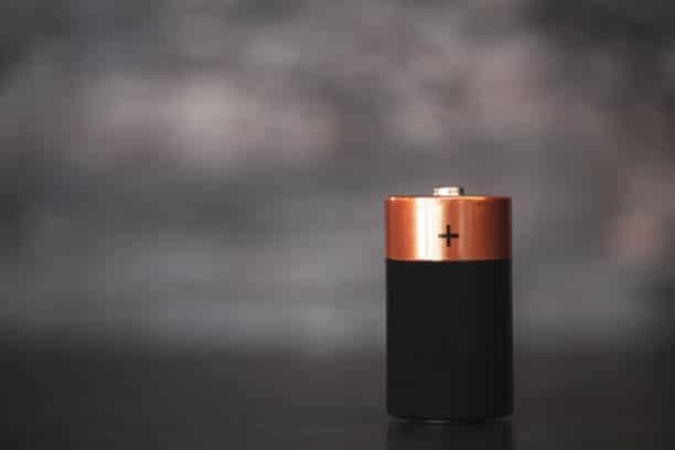 Close-up of a single AA battery highlighting positive terminal
