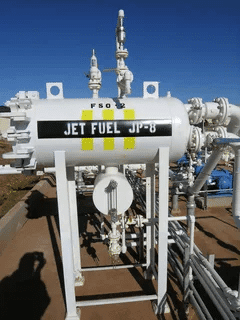 Jet Fuel JP-8 labeled tank with piping system in an outdoor fuel storage facility.