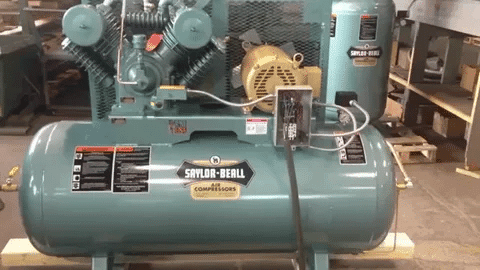 Large Saylor Beall air compressor with motor, safety valves, and durable tank design.
