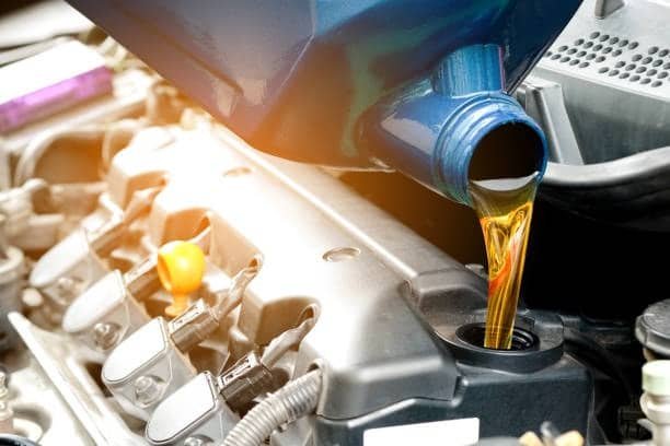 Pouring engine oil into a diesel engine after running out of fuel, an essential step before restarting.
