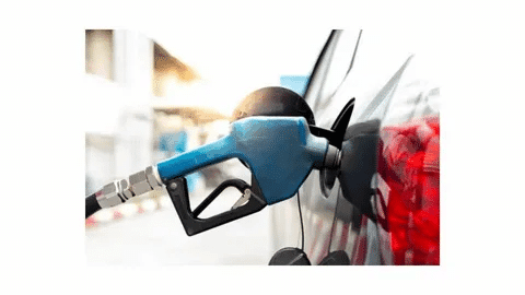 Blue gasoline nozzle attached to a car fuel tank.