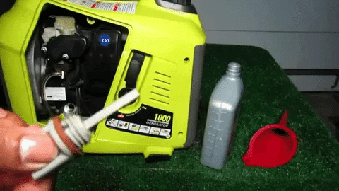 Technician holding dipstick to check oil level in a generator.