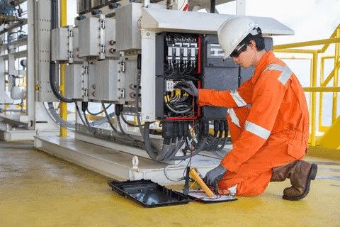 Worker conducting generator electrical testing for NFPA 110 compliance
