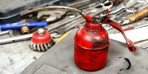 Red oil can placed on a workbench for generator oil change.