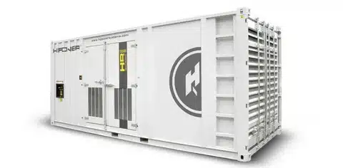 Large containerized industrial generator unit with ventilation panels and access doors.