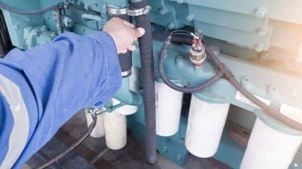 Technician priming a diesel fuel system to remove air after running out of fuel.