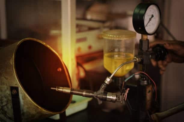 Diesel injector nozzle being tested for performance before engine restart.